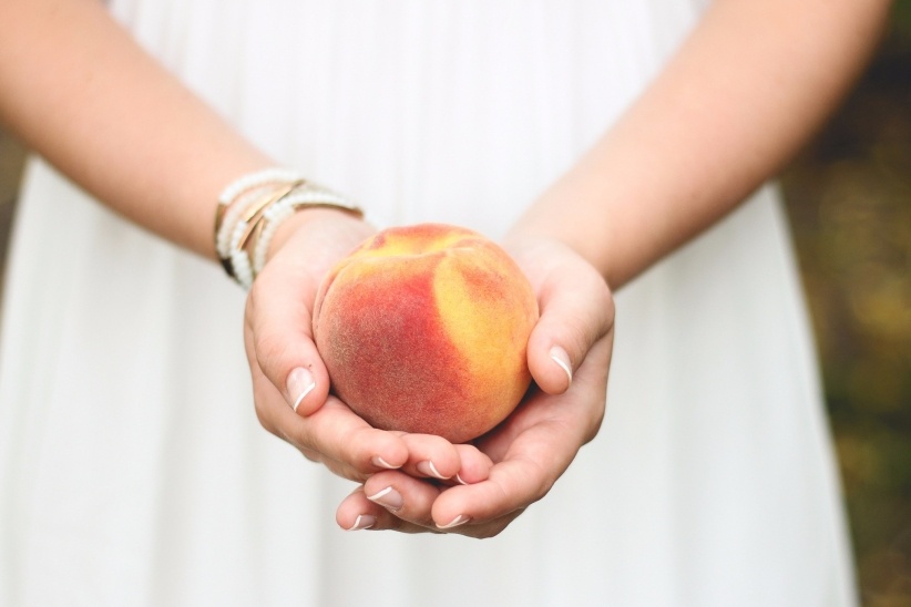 girl tenderly holding a peach